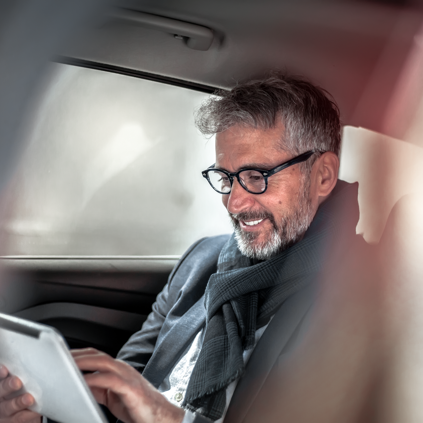 Picture of a man with a tablet in a car